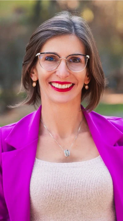 Retrato de Amanda Dreher, de blazer rosa, sorrindo